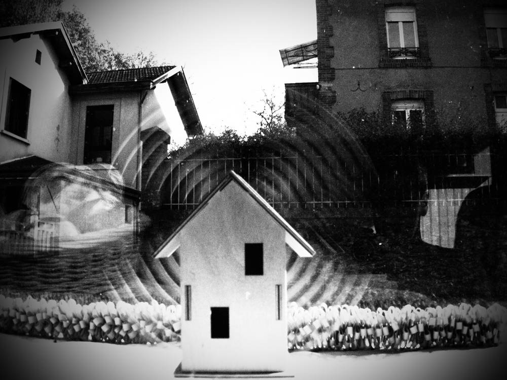 photo noir & blanc d'un petit moulin à vent en bois et énergie solaire, dont les pales tournent dans une vitrine de boulangerie.
