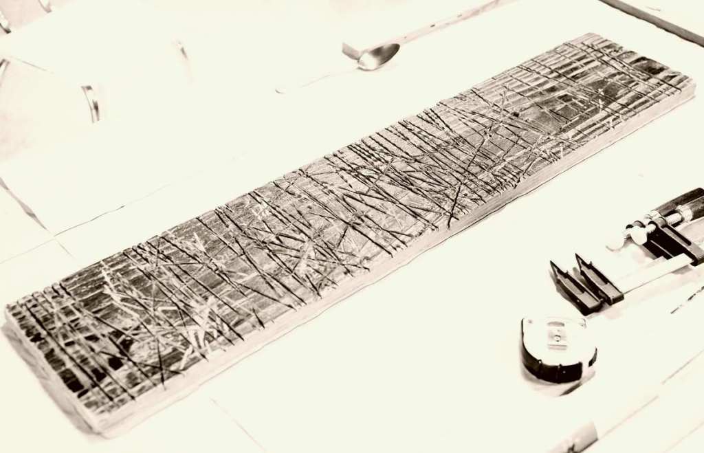 planche de bois marquée de lignes en tous sens qui sont les traces laissées par les coupes d'une disqueuse sur un chantier. Vue générale